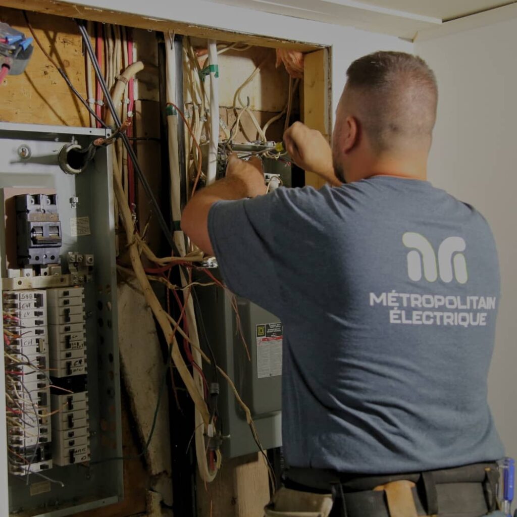 Électricien procédant à l'installation d'un nouveau panneau électrique.